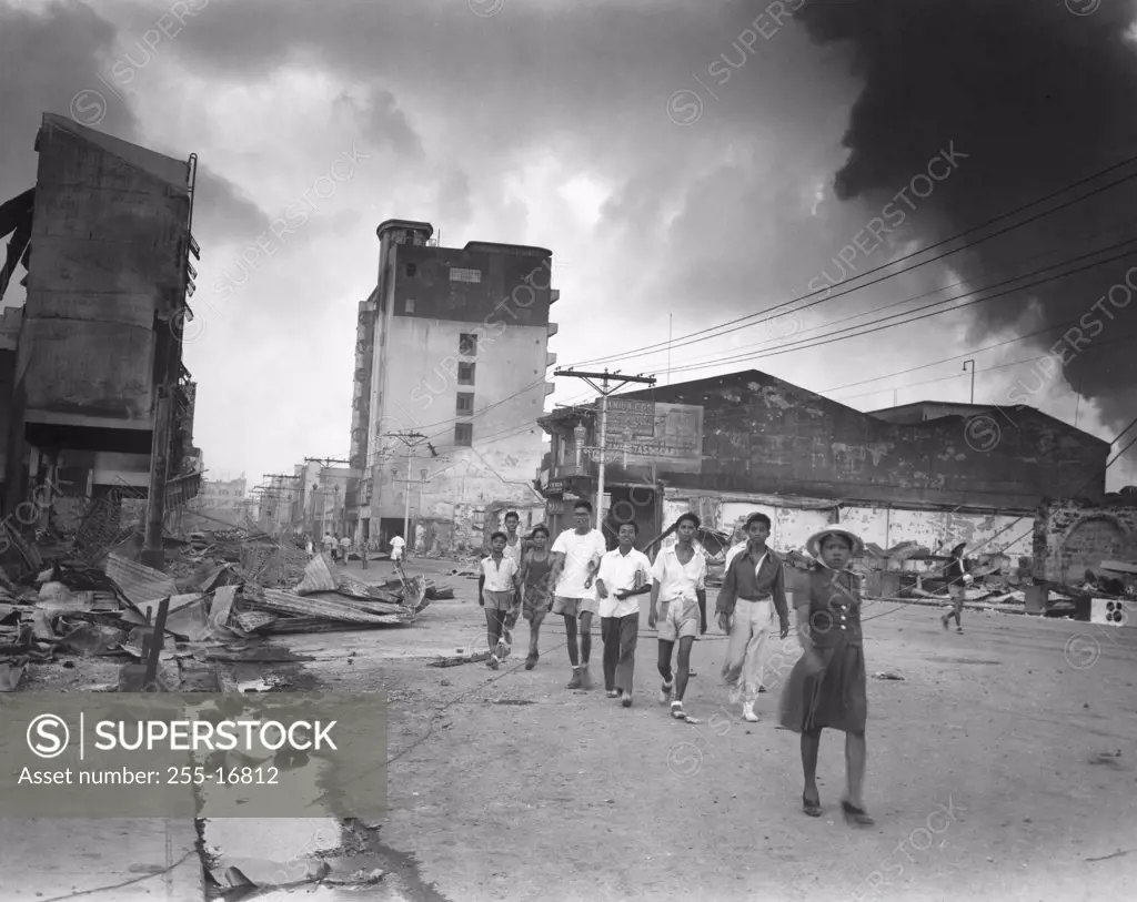 Group of people walking in front of burning buildings, Manila, Philippines