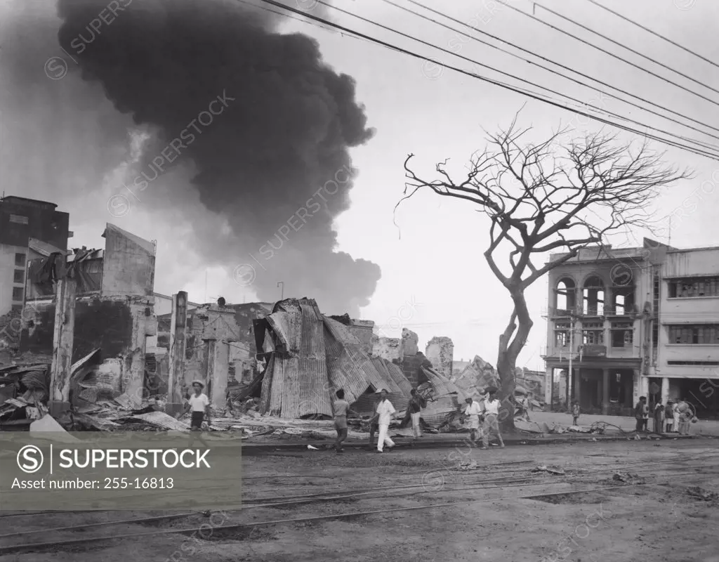 Group of people walking in front of burning buildings, Manila, Philippines