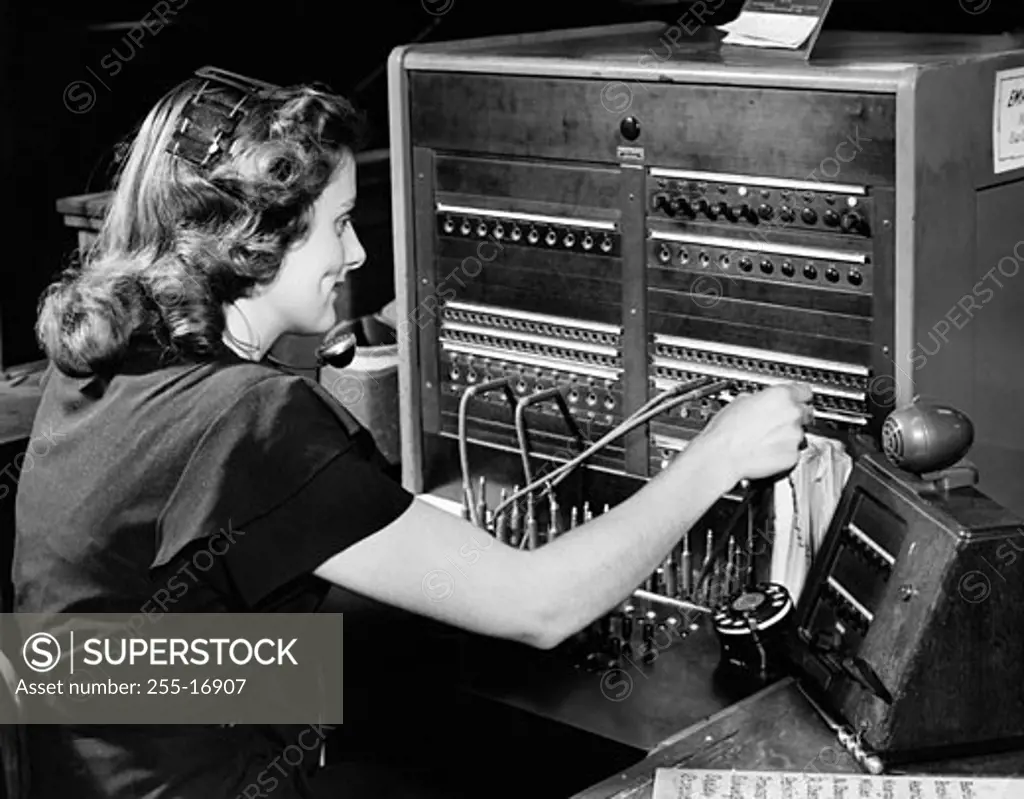 Side profile of a female telephone operator operating a switchboard