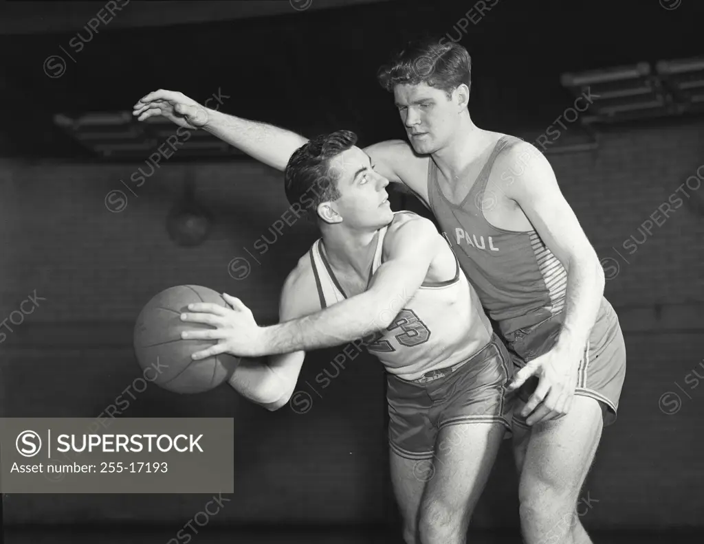Vintage Photograph. Basketball player with ball tries to keep it away from defender