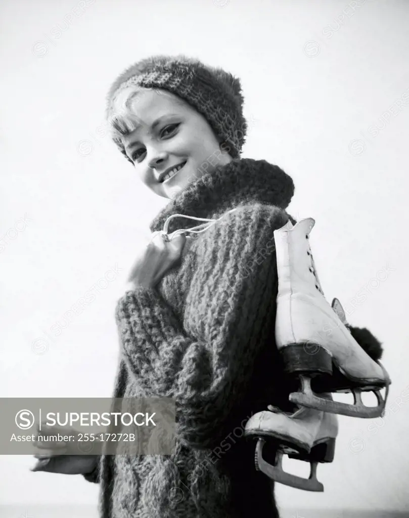 Portrait of a teenage girl carrying a pair of ice skates