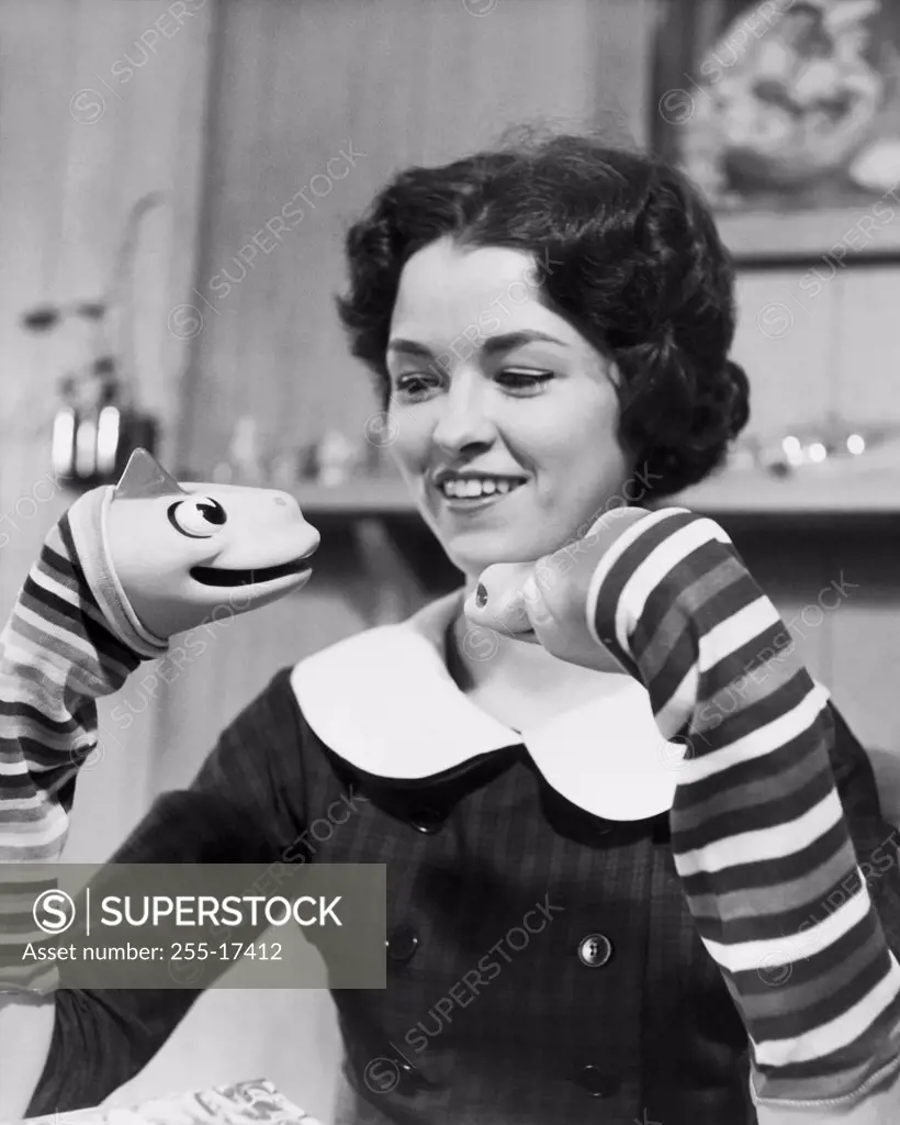 Young woman playing with puppets