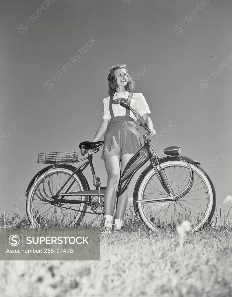 Vintage Photograph. Woman on bicycle in field looking off camera
