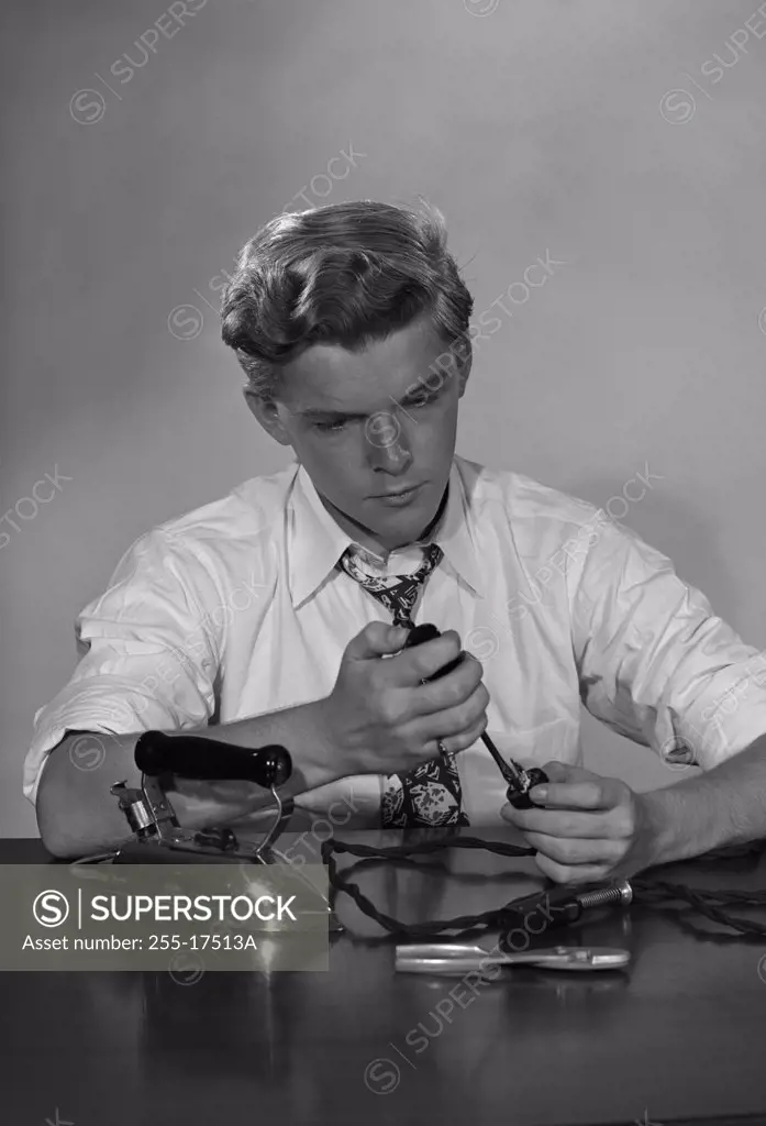 Teenage boy repairing iron