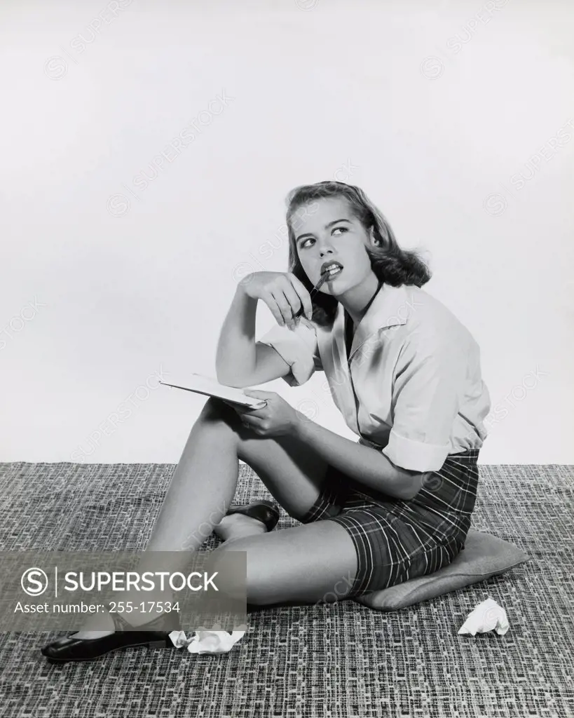 Teenage girl holding a book and a pencil