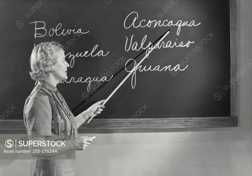Vintage photograph. Side profile of a female teacher teaching in the classroom