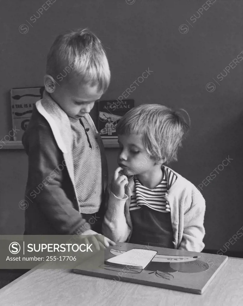 Boy standing near a girl and looking at a picture