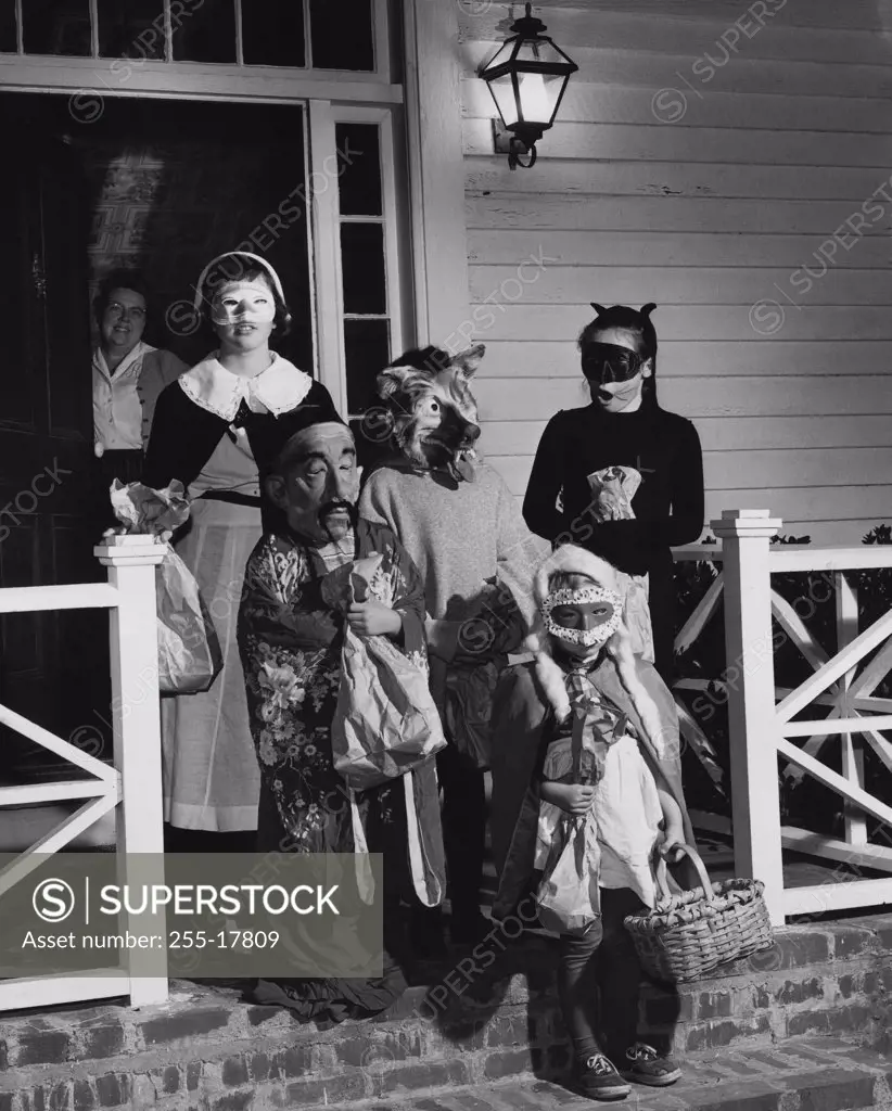 Five children wearing Halloween costumes for trick or treating