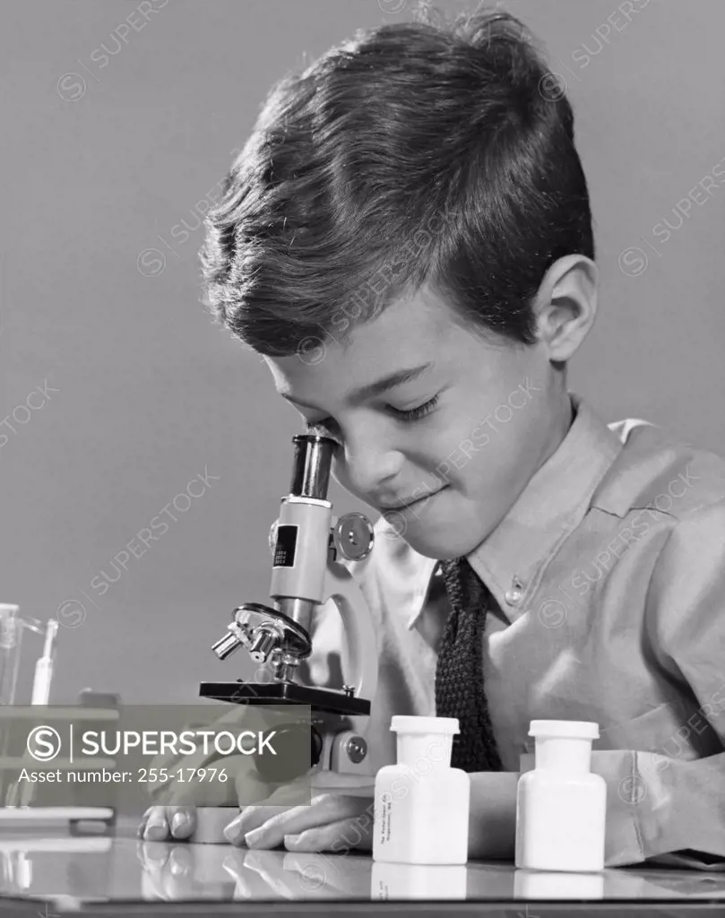 Schoolboy looking through a microscope