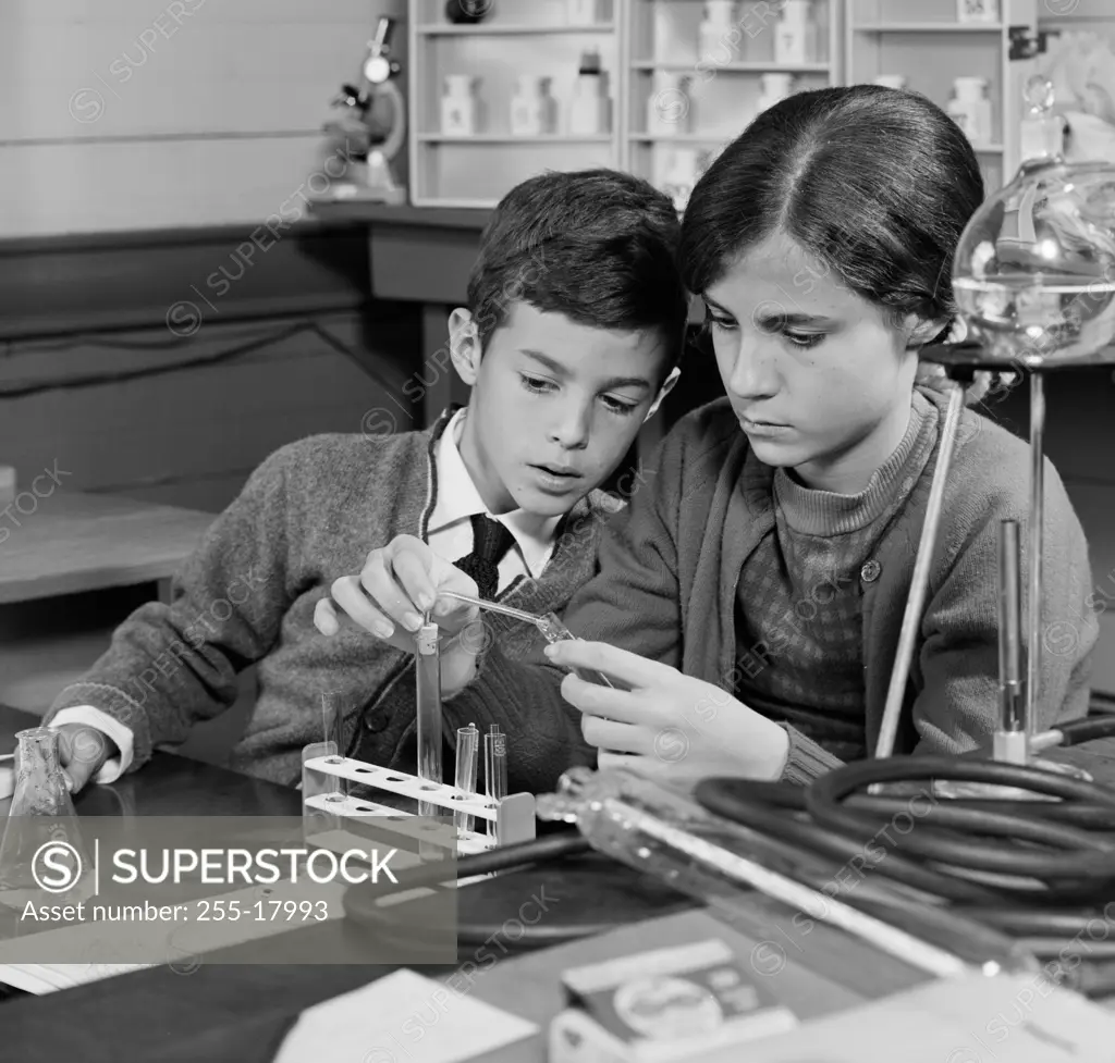 Boy and a girl performing an experiment in a chemistry laboratory