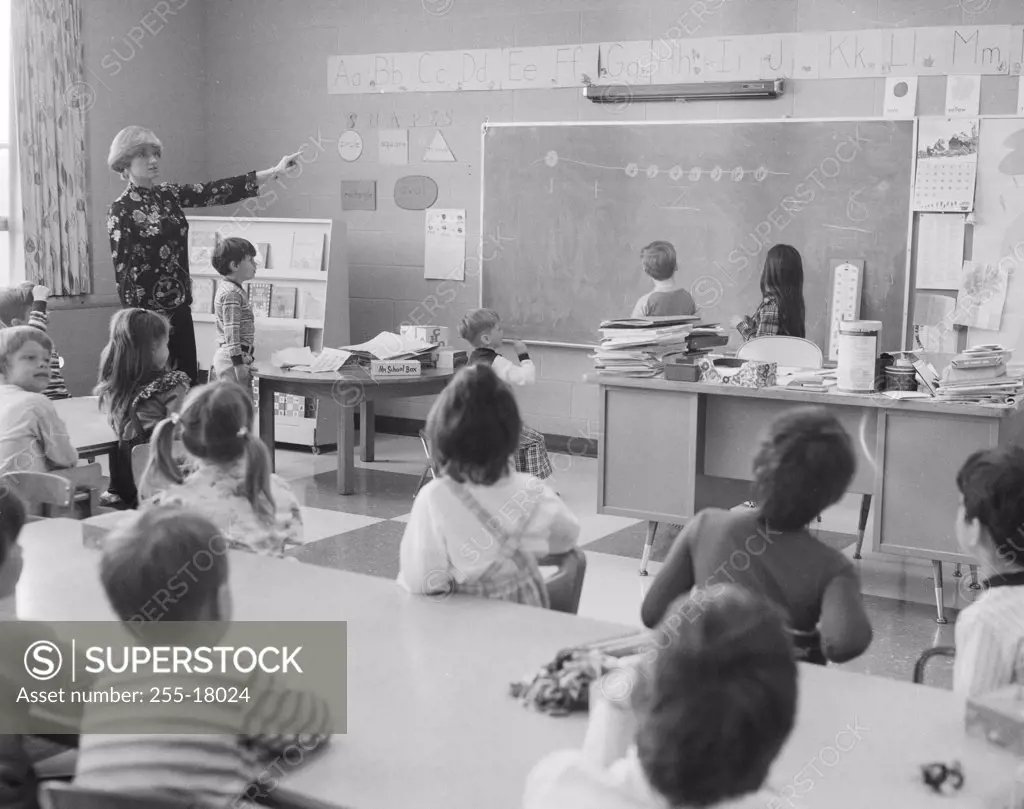 Female teacher pointing to a blackboard