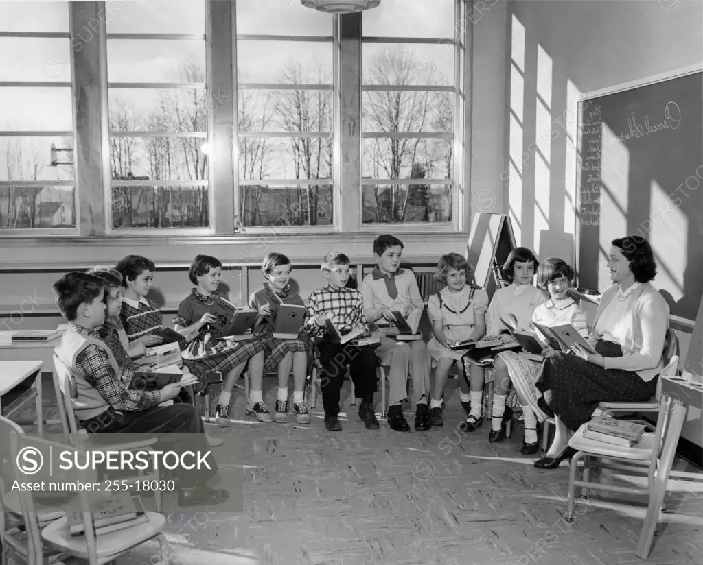 School children reading with their teacher