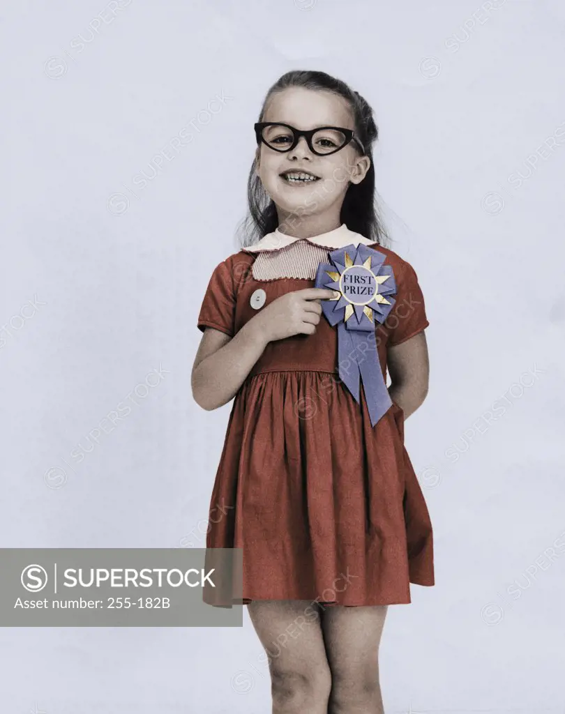 Portrait of a girl pointing to her first place ribbon