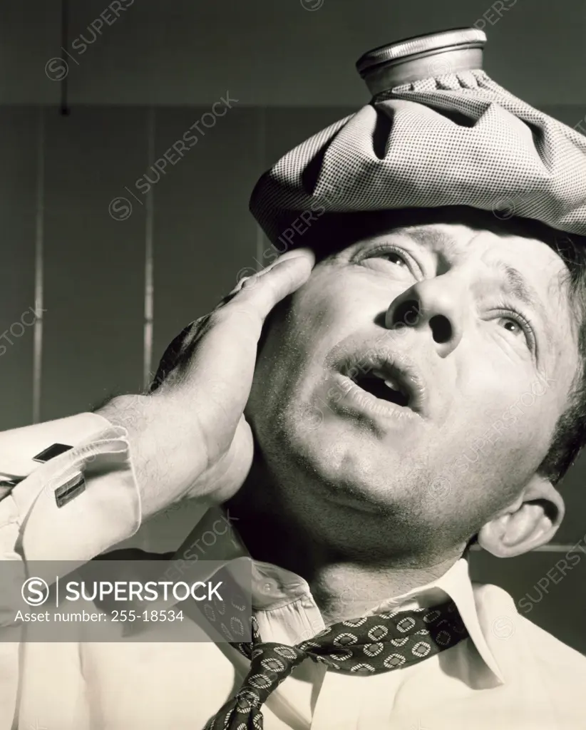 Close-up of a mature man with an ice pack on his head