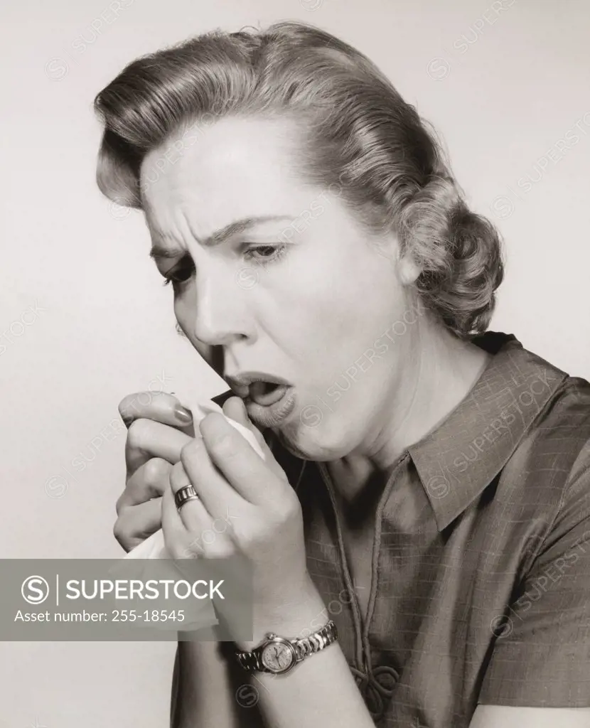 Close-up of a mid adult woman coughing