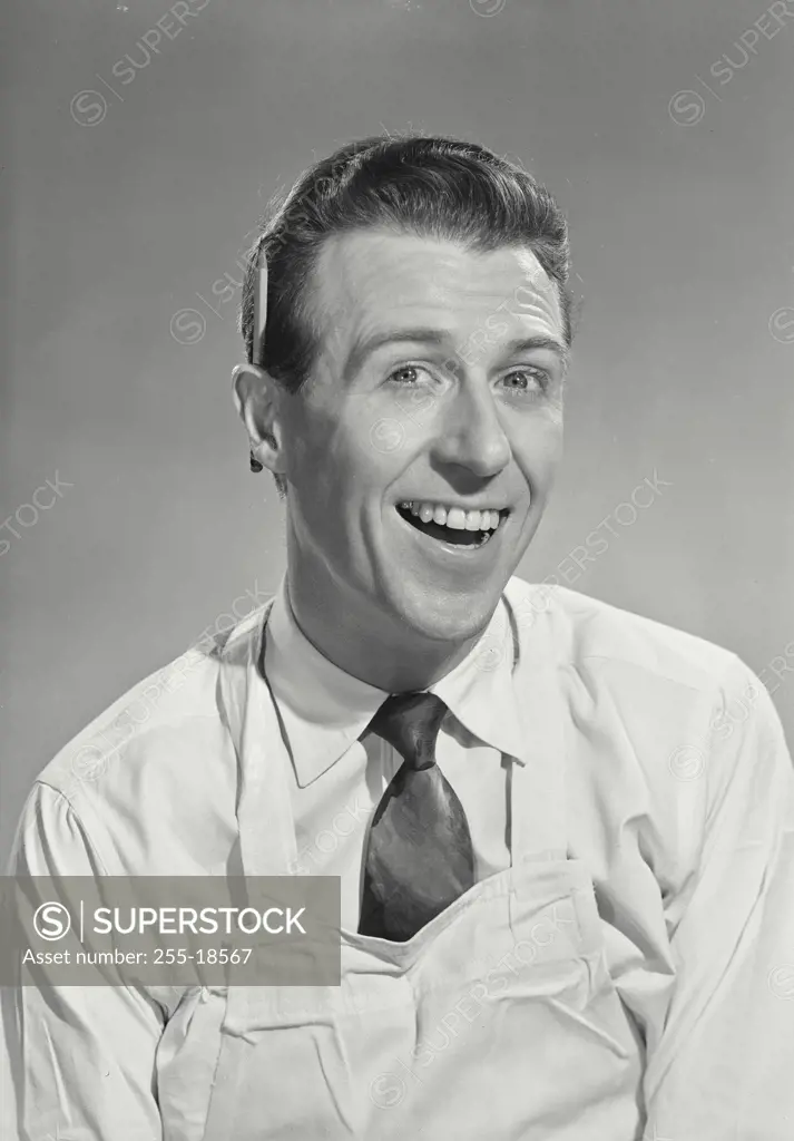 Vintage Photograph. Smiling brunette man in white shirt and tie wearing white aprin