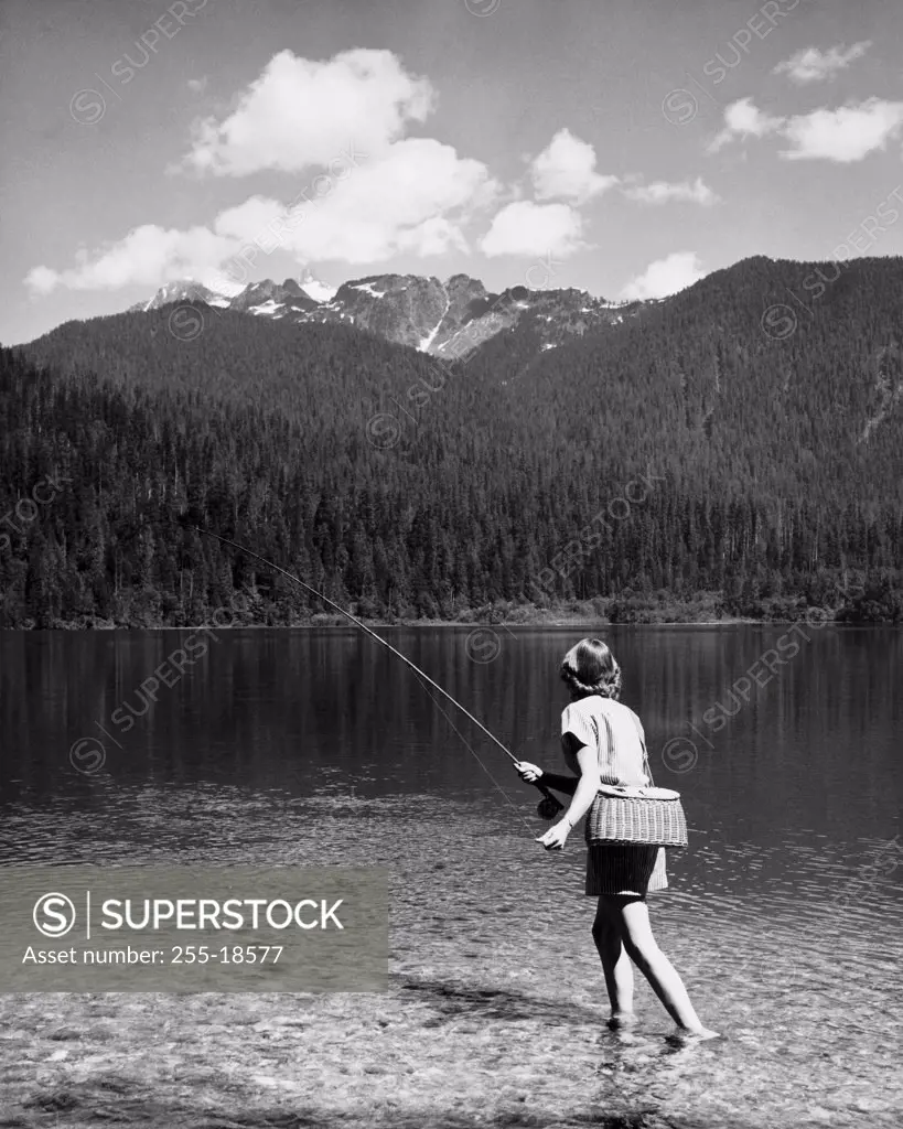 Rear view of a woman fishing in a lake, Baker Lake, Mount Baker-Snoqualmie National Forest, Washington, USA