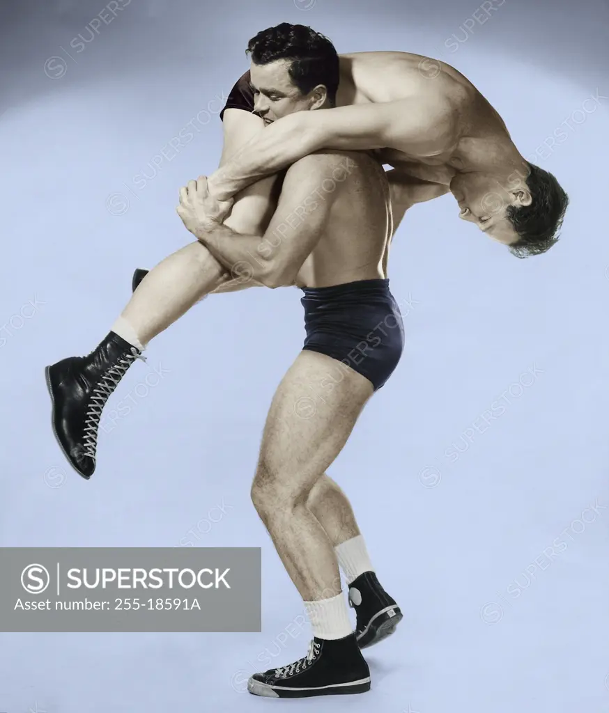 Two young adult men wrestling