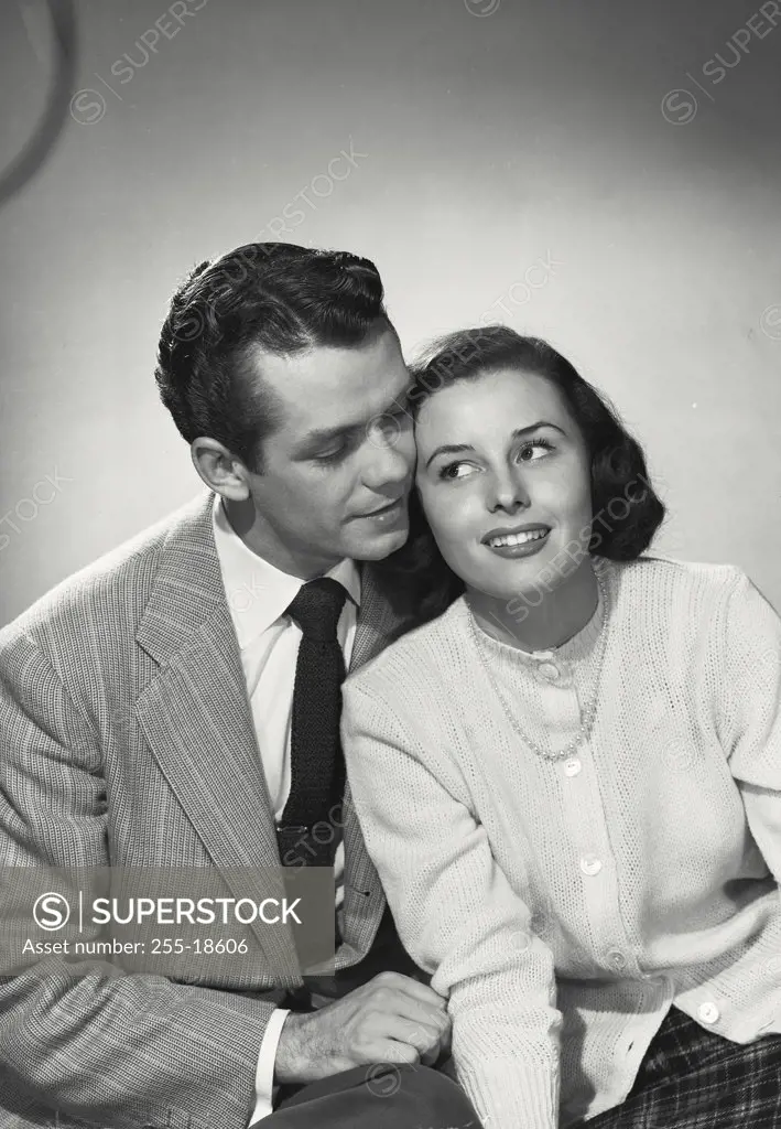 Vintage photograph. Portrait of male/female couple sitting holding faces close together