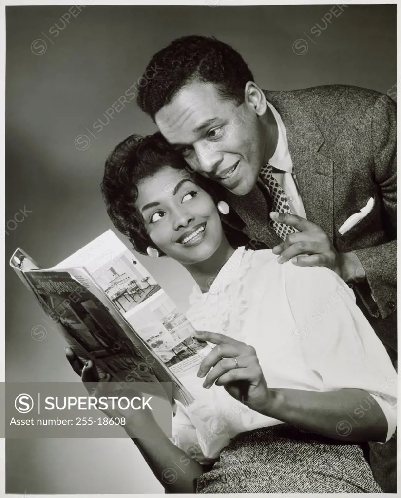 Close-up of a young couple looking at a catalog