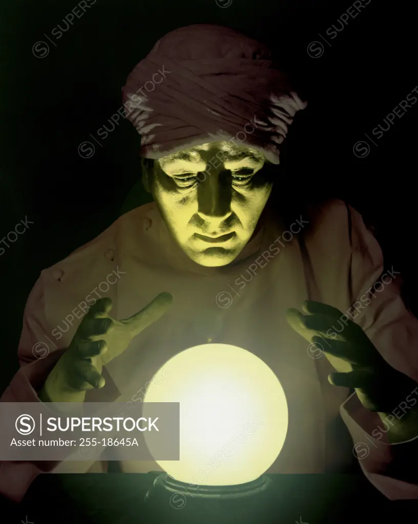 Close-up of a fortune teller looking into a crystal ball