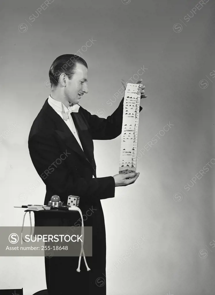 Vintage Photograph. Side profile of a magician performing a card trick