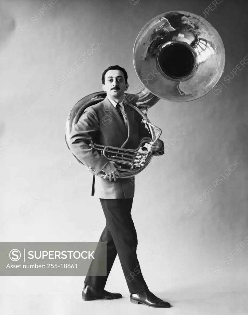 Portrait of mid adult man carrying a tuba