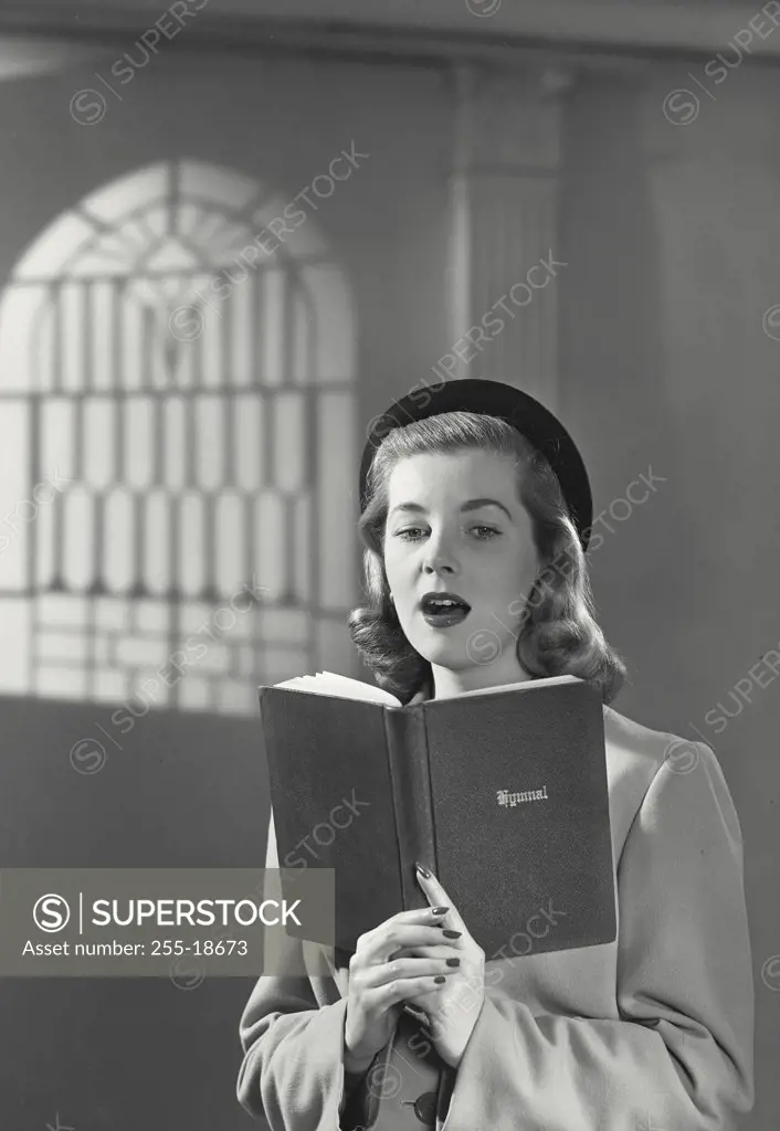 Vintage photograph. Close-up of a young woman in church reading from bible