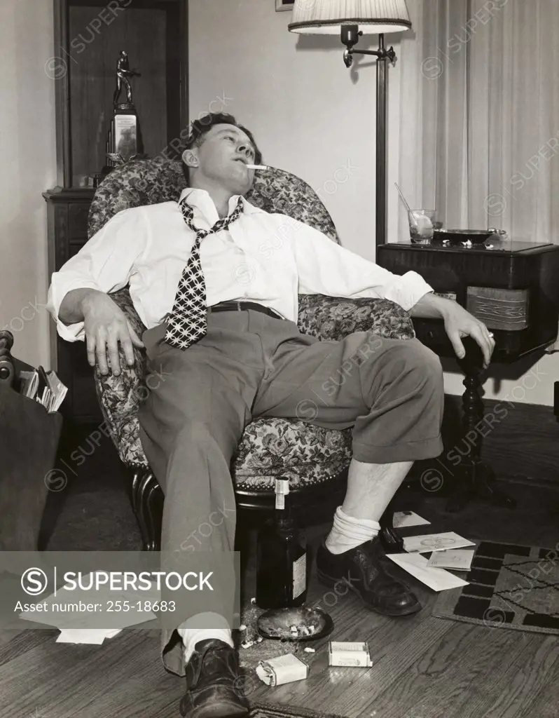 Young man resting on an armchair, drunk
