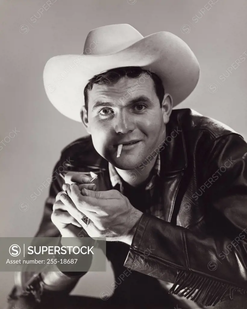 Portrait of a cowboy lighting a cigarette