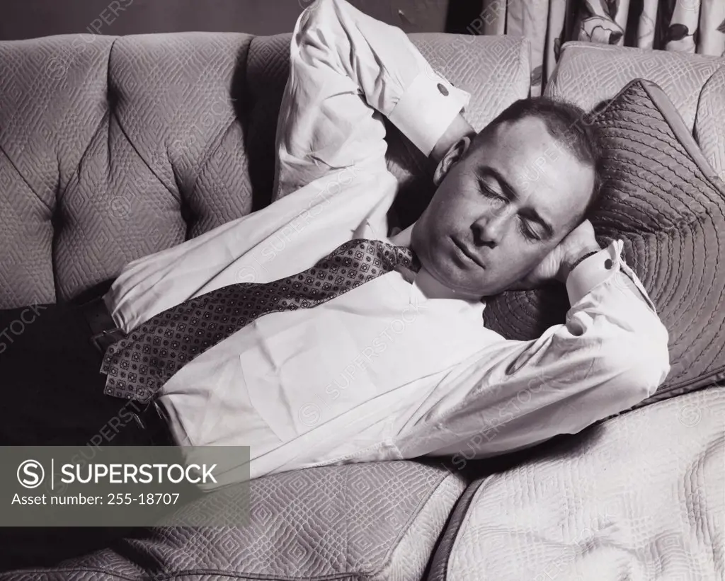 Close-up of a mid adult man sleeping on a couch