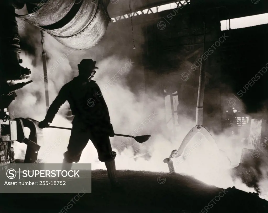 Worker stoking furnace in a steel foundry