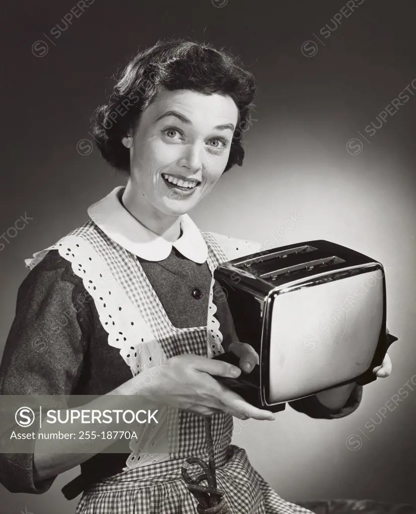 Studio shot of woman holding toaster