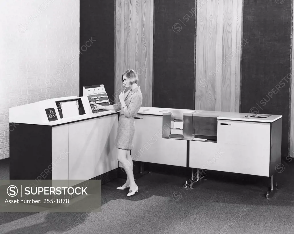Side profile of a businesswoman working on a data processing system, 1969