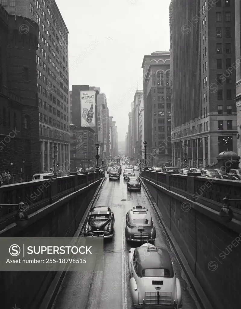 Vintage photograph. Rainy day, Park Avenue ramp below grand Central Station. Cars. Taxi.