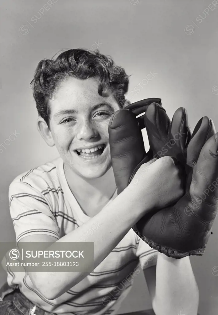 Vintage photograph. Boy smiling punching center of baseball glove