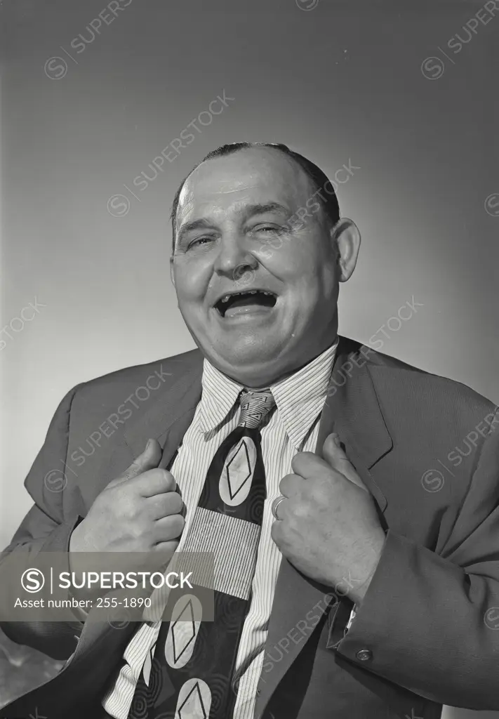 Vintage Photograph. Man in suit holding jacket smiling wide at camera