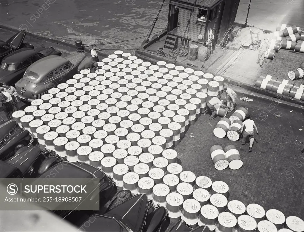 Vintage photograph. Processing barrels of marine lubricant for shipment on North River