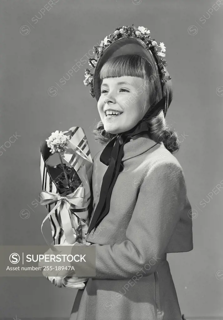 Vintage photograph. Portrait of young girl smiling holding flowers wearing bonnet with flowers