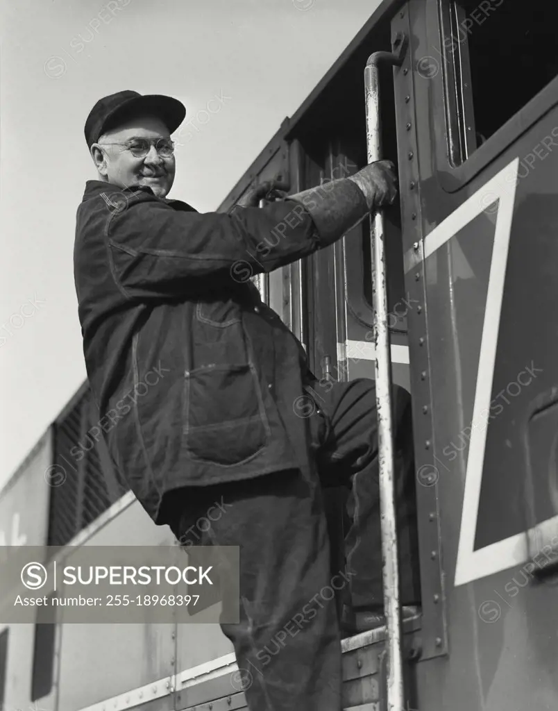 Vintage photograph. engineer climbing into cab of locomotive