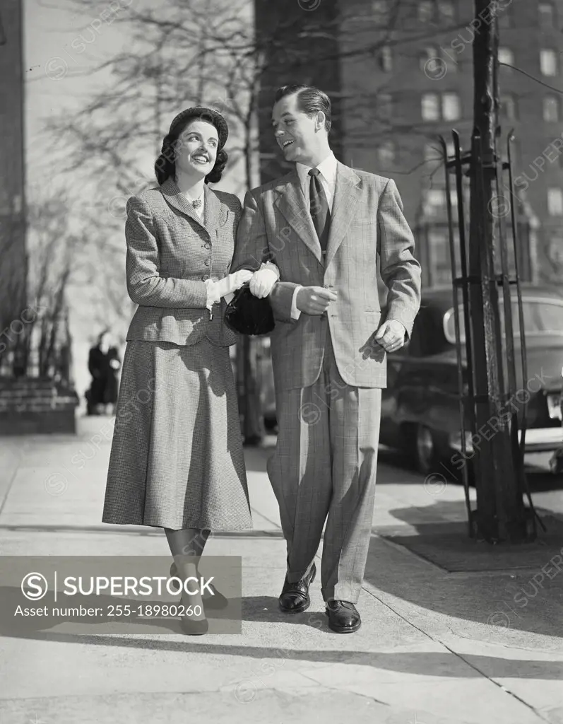 Vintage photograph. Couple walking on sidewalk in city