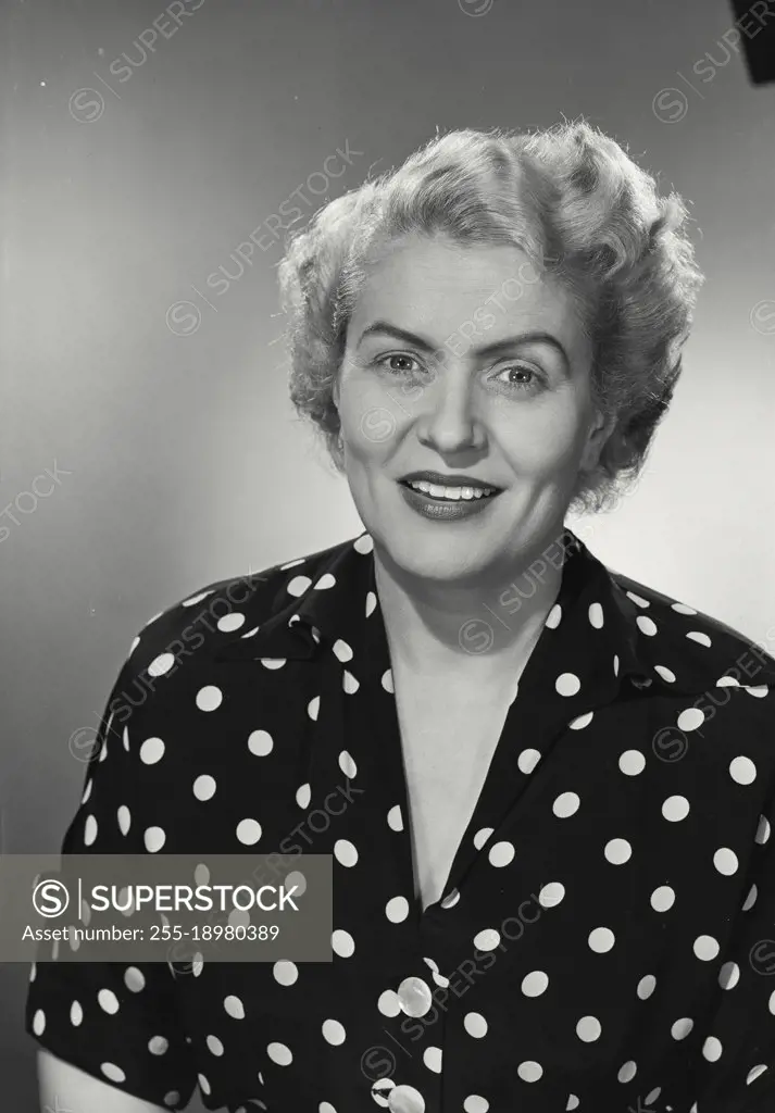 Vintage photograph. woman in polka dot shirt smiling at camera.