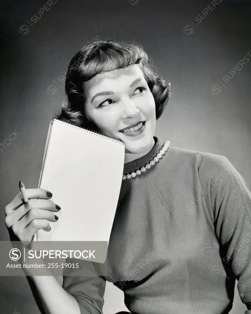 Close-up of a businesswoman holding a pen and a notepad, 1958