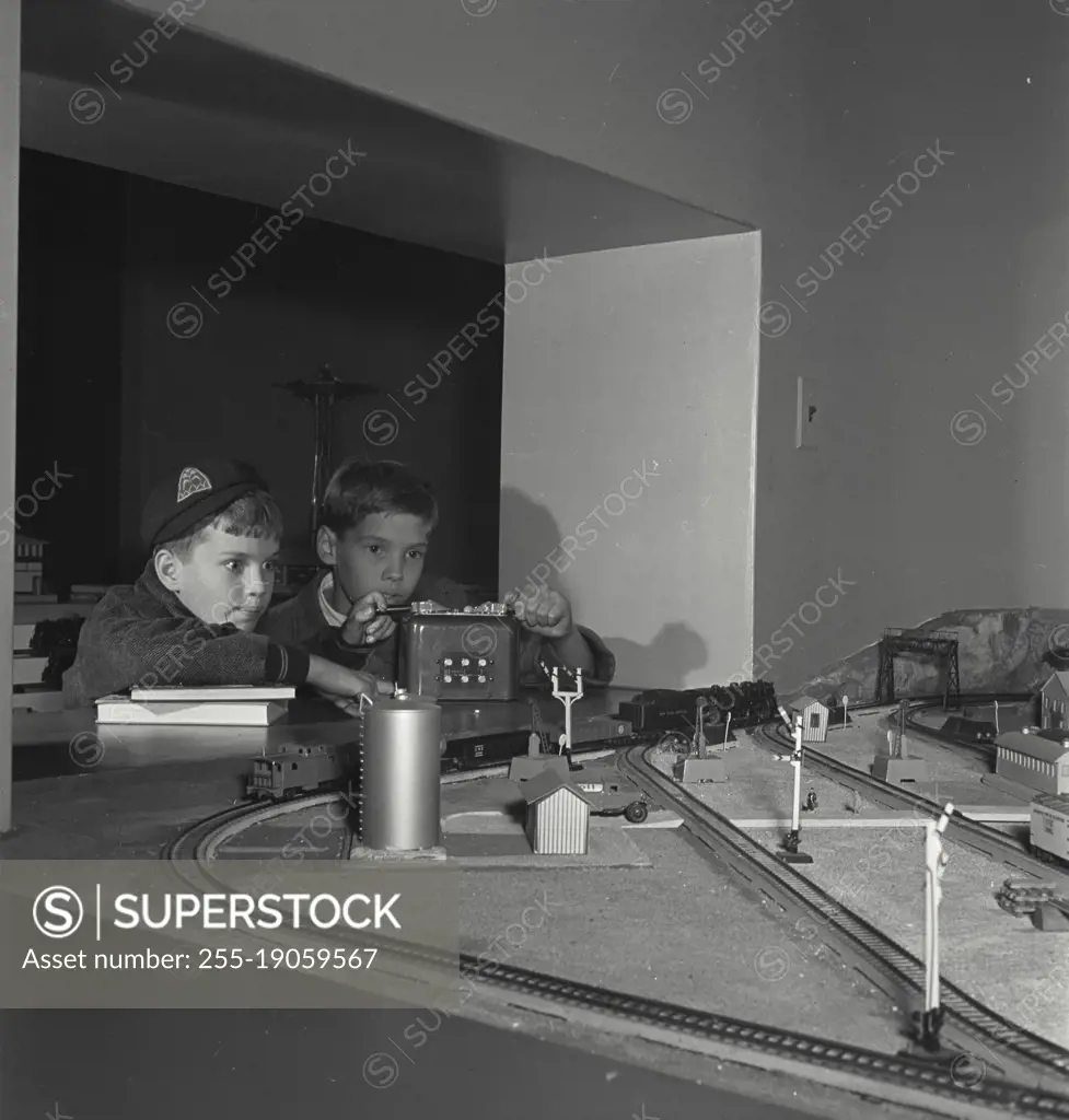 Vintage photograph. Two young boys playing with model train set