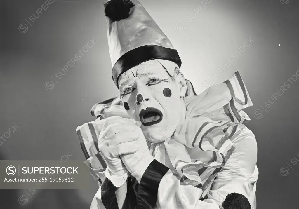 Vintage photograph. Portrait of clown in silly hat with shocked expression.
