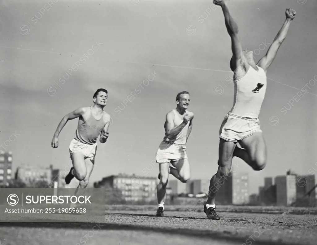Vintage photograph. Runners sprinting through finish line.