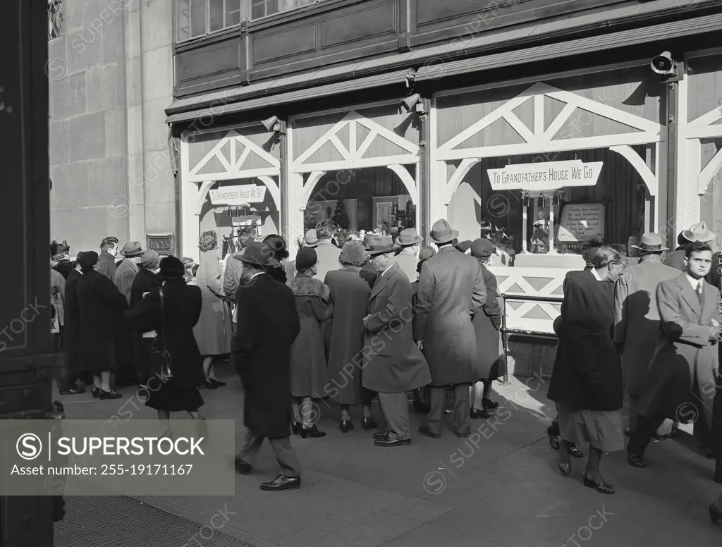 Vintage photograph. crowds out in front of shops gazing through window