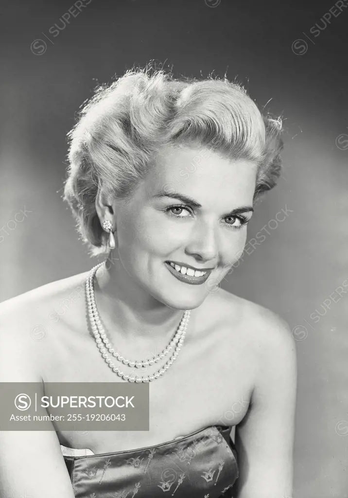 Vintage photograph. Woman in strapless dress smiling at camera