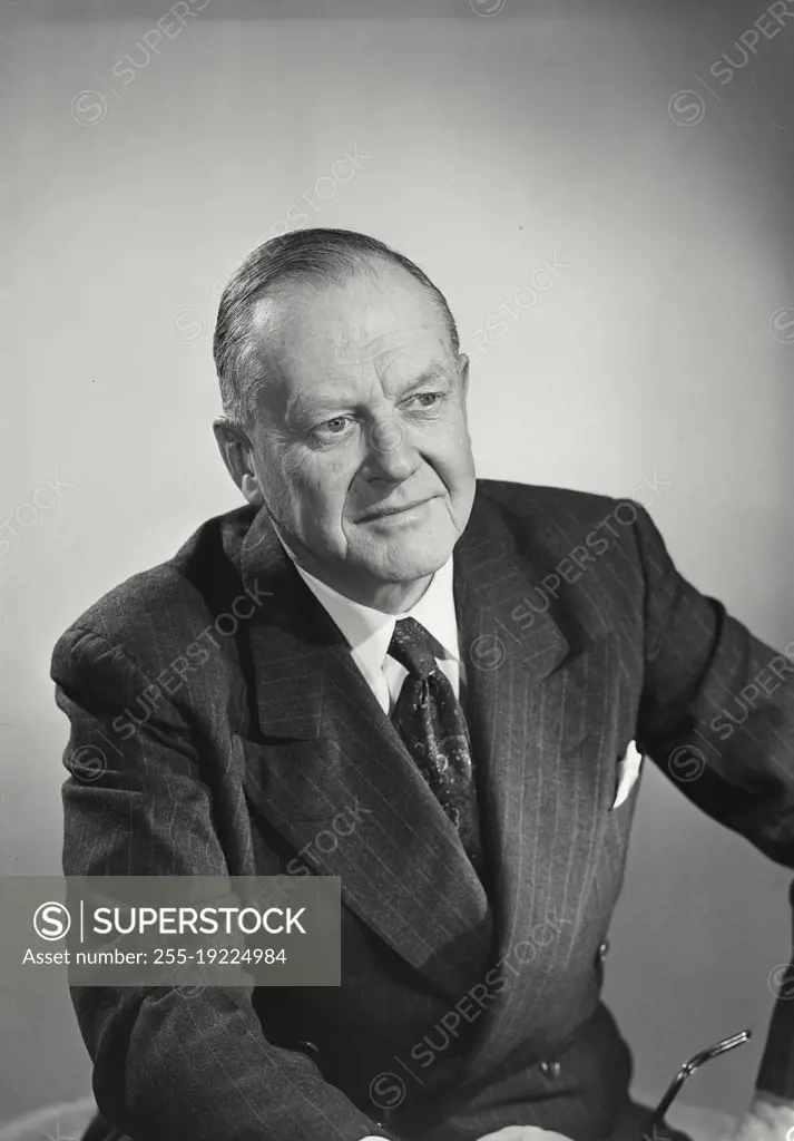 Vintage photograph. Older man in pinstripe suit looking at camera