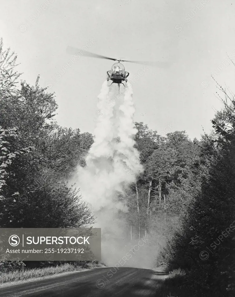 Vintage photograph. Bell helicopter performing Black fly fogging operations